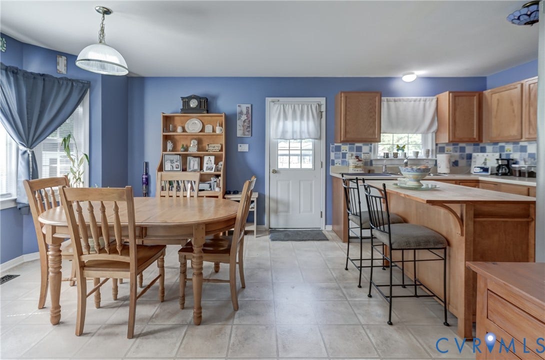 4229 Greenbriar Drive, Chester, VA 23831 Tile flooring, wood-finish cabinetry, built-in breakfast bar, and a tiled backsplash