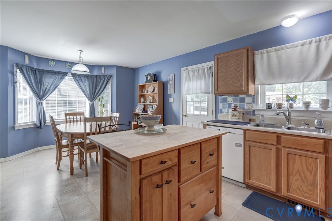 4229 Greenbriar Drive, Chester, VA 23831 Kitchen featuring light wood cabinetry, a central island, a tile backsplash, and a sink with a window above