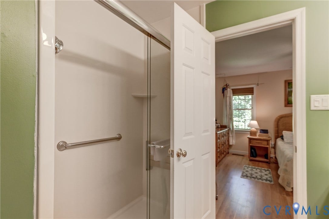 4229 Greenbriar Drive, Chester, VA 23831 Shower enclosure with clear glass door, built-in shelving, and a grab bar