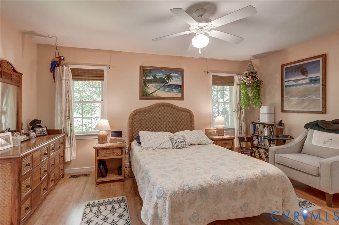 4229 Greenbriar Drive, Chester, VA 23831 Wood-finish flooring, ceiling fan with light fixture, multiple windows, and a built-in shelving unit