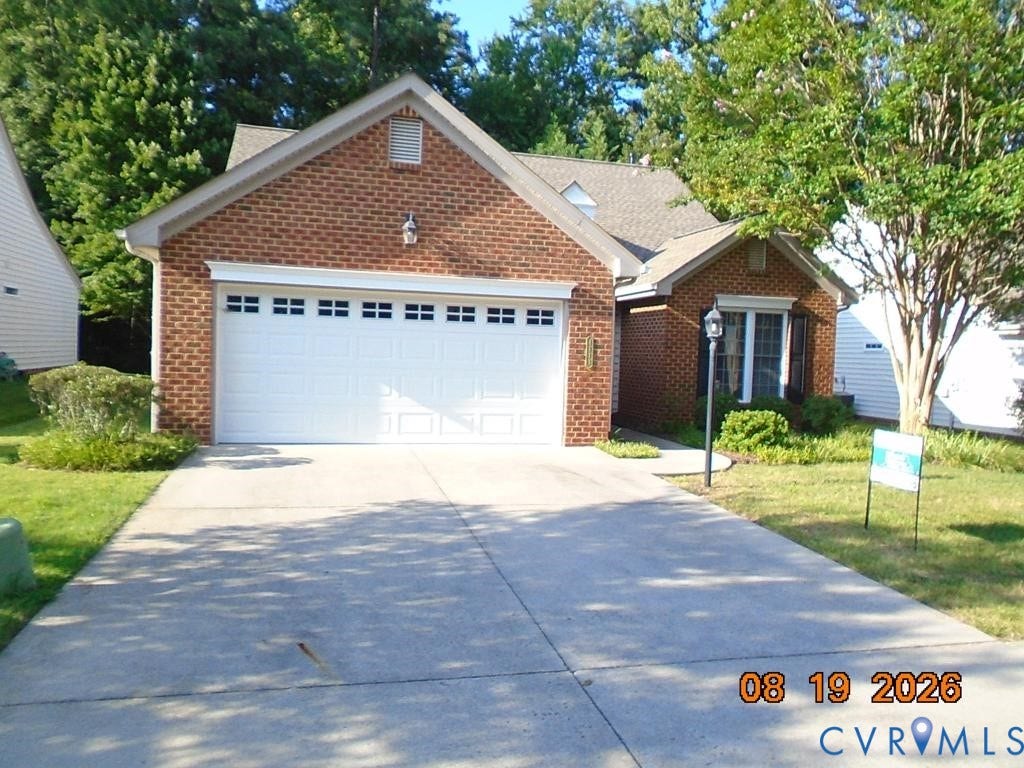 4113 Coles Point Way, Glen Allen, VA 23060 Brick exterior with a prominent two-car garage, concrete driveway, and mature landscaping