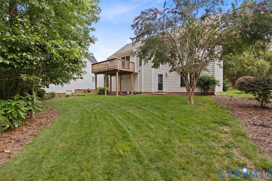 13819 Ashbourne Hollow Circle, Birkdale, Chesterfield, VA 23832 Expansive backyard with a manicured lawn, established trees, and a raised wood-finish deck