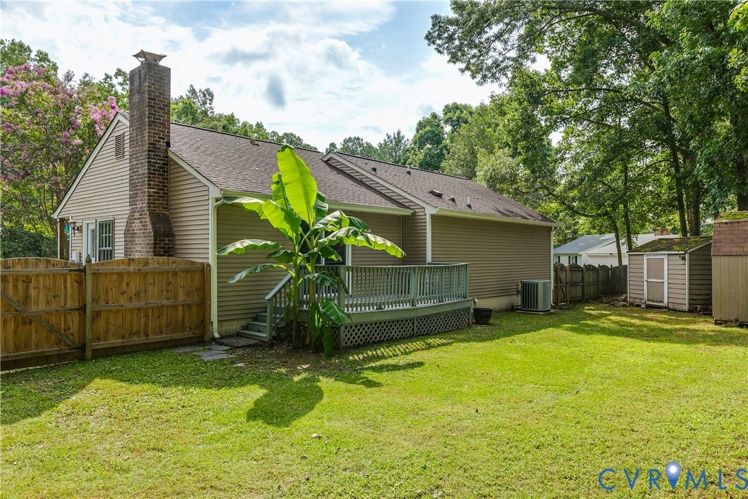 4116 Bronholly Road, Chesterfield, VA 23832 Expansive, fully fenced backyard featuring a wood deck with lattice skirting, mature trees.