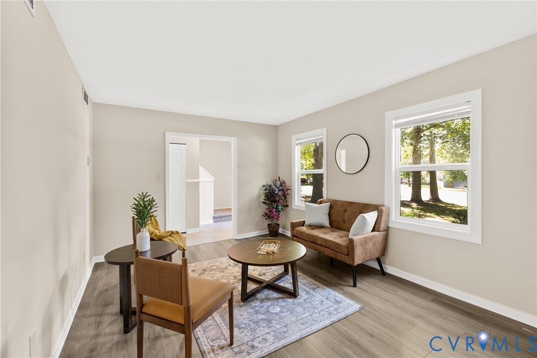 5401 Solaris Drive, Chesterfield, VA 23832 Bright and airy living space featuring large windows with natural light, wood-finish flooring throughout, neutral wall finishes, and round coffee table with matching seating arrangements