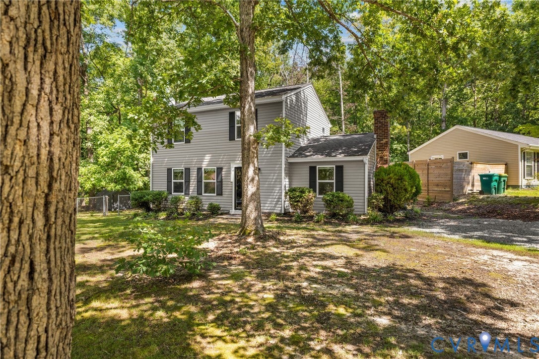 5401 Solaris Drive, Chesterfield, VA 23832 Two-story residence with gray siding, dark window shutters, and a prominent brick chimney