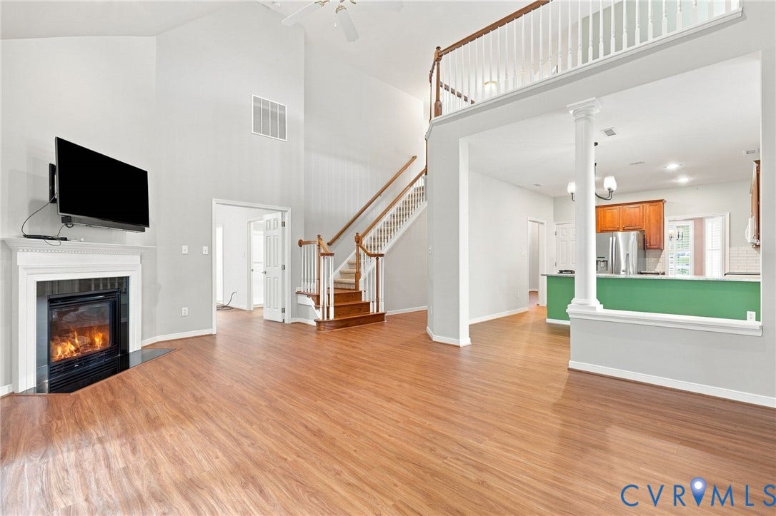 Vaulted ceilings, wood-finish flooring, and a fireplace with a mantel