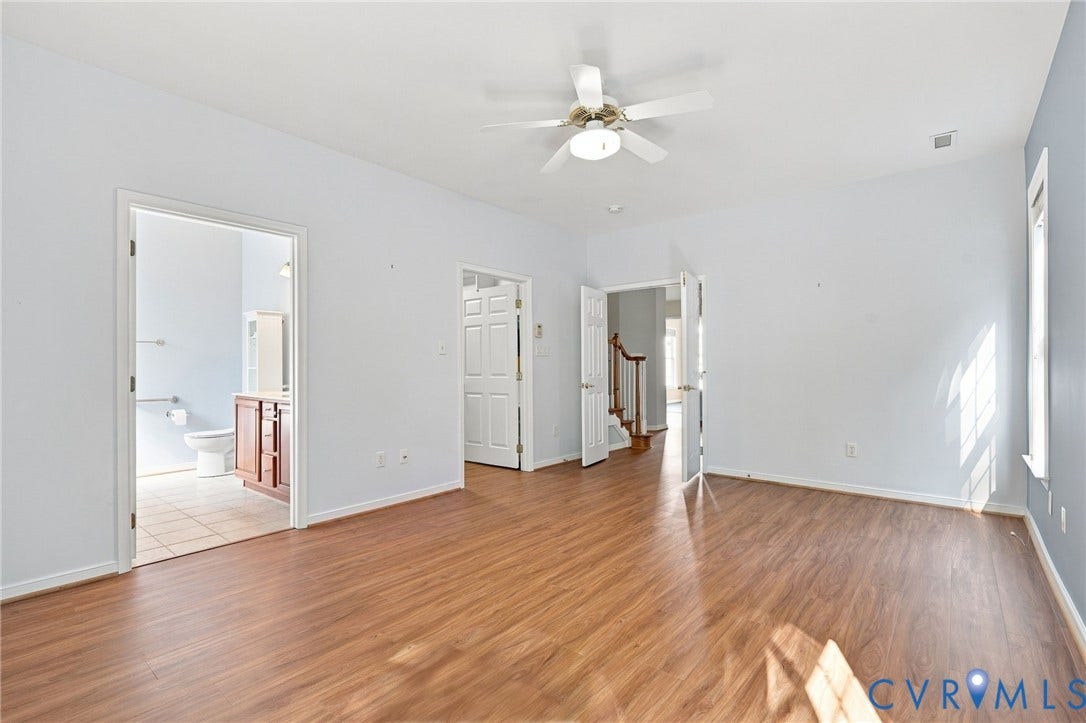 Wood-finish flooring throughout, ceiling fan with integrated lighting, and multiple doorways