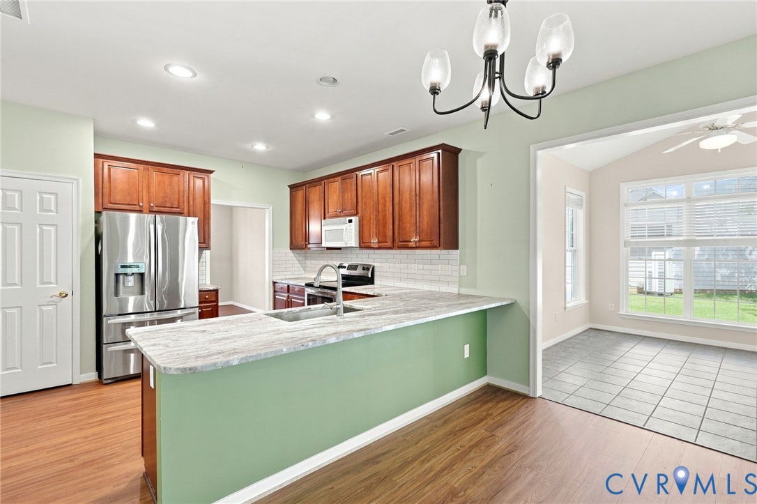 Kitchen featuring wood-finish cabinetry, stainless steel appliances, and a tiled backsplash
