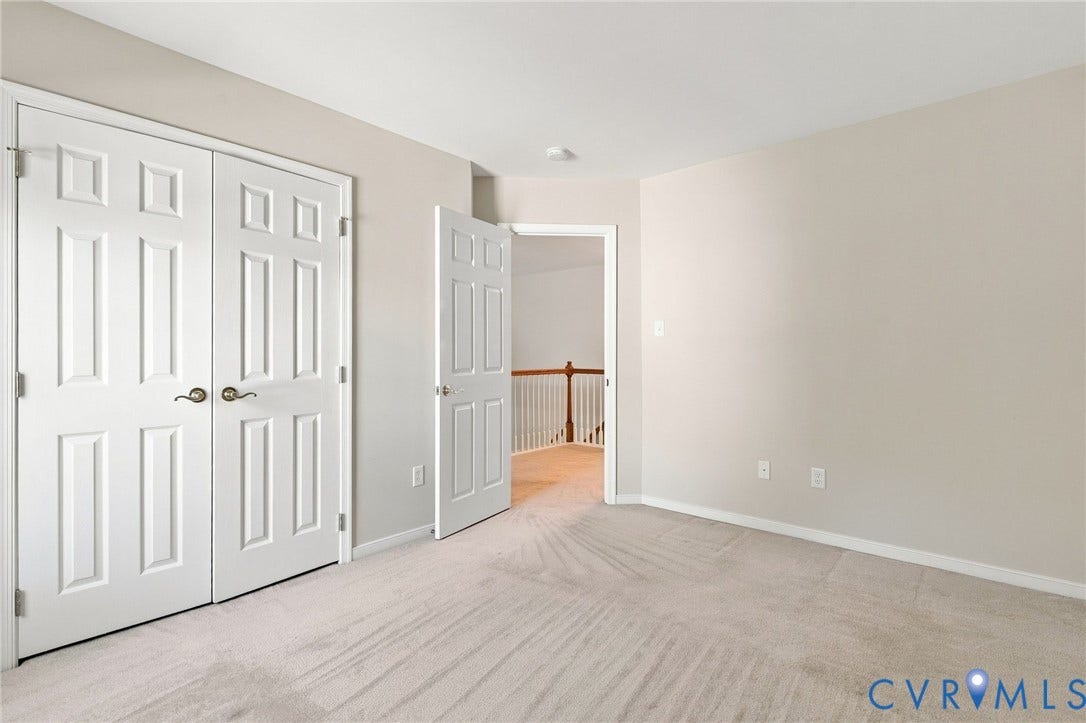 Neutral wall paint, white trim, paneled doors, carpet flooring, and ceiling lighting