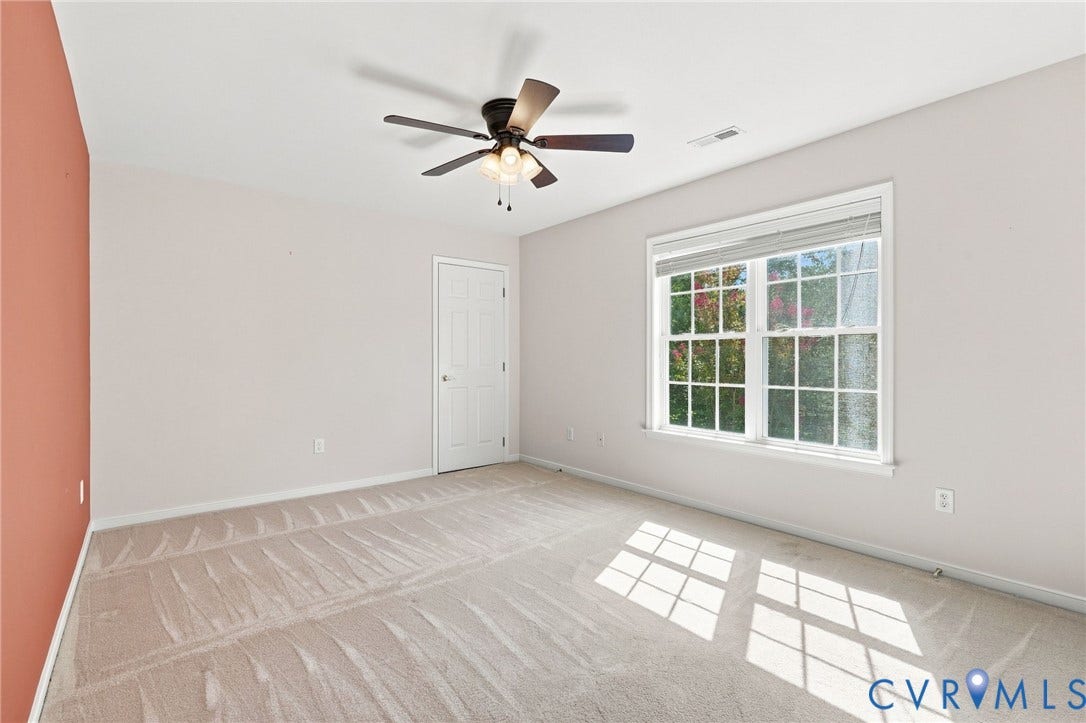 Carpeted flooring, white trim, ceiling fan with integrated lighting, and a double-hung window