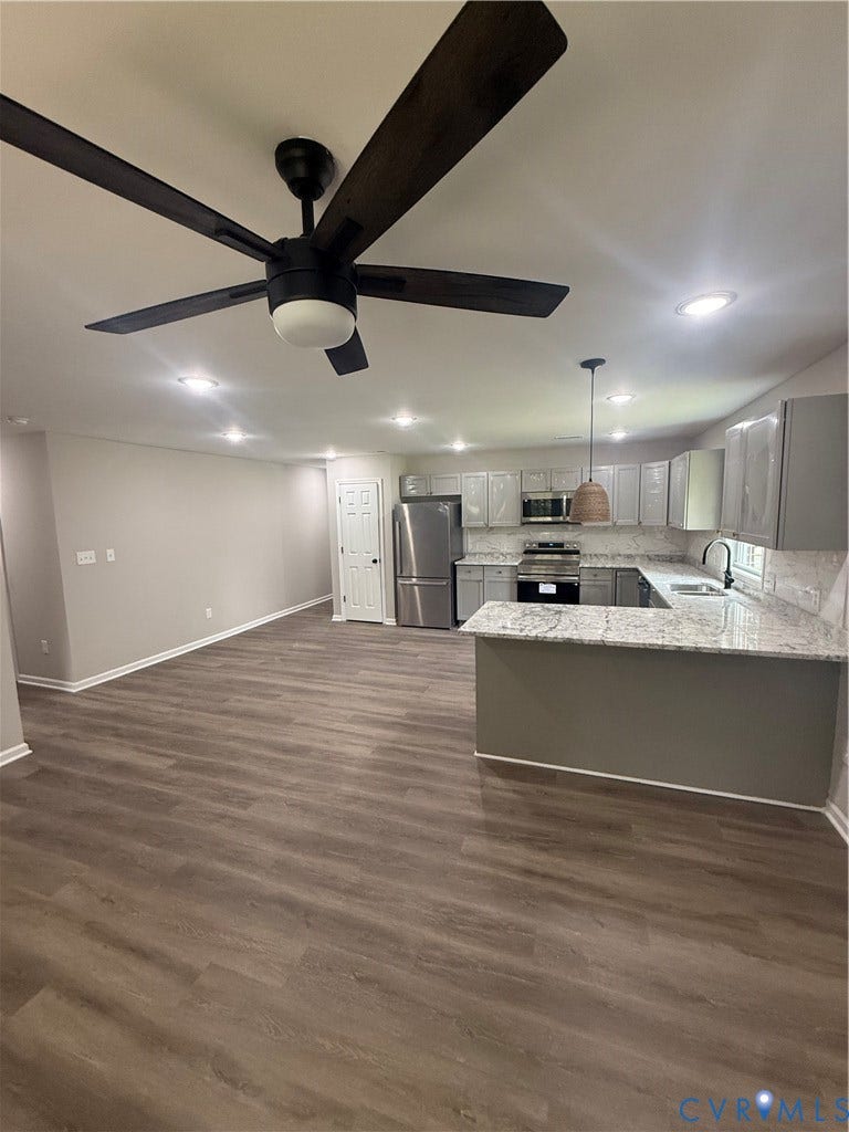 3430 The Loop Rd, Glendale, Montross, VA 23231 Wood-finish flooring throughout, recessed lighting, ceiling fan with integrated light, kitchen with grey cabinetry and granite countertops, and stainless steel appliances