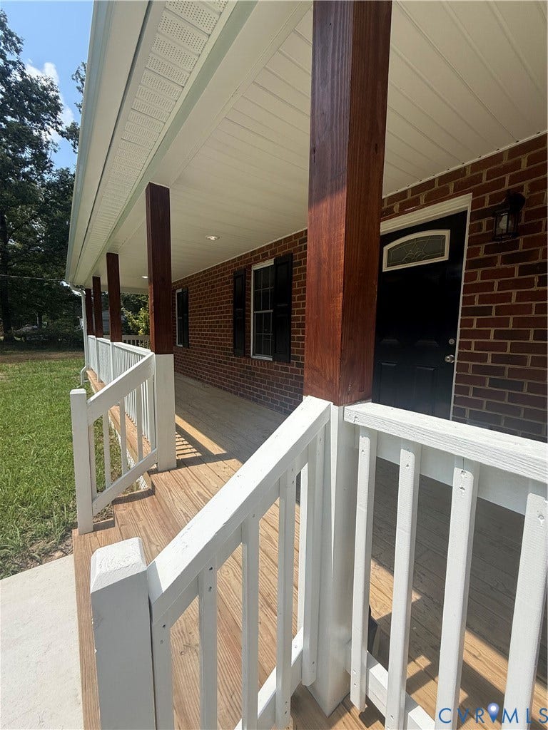 3430 The Loop Rd, Glendale, Montross, VA 23231 Expansive covered front porch with wood flooring, white railings, and substantial wood support columns