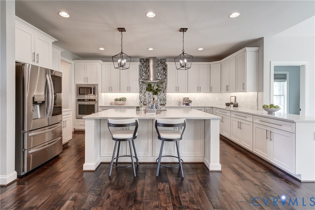 11515 Grey Oaks Estates Run, Grey Oaks Estates, Glen Allen, VA 23059 White cabinetry with under-cabinet lighting, stainless steel appliances, a center island with countertop seating, recessed lighting, and wood-finish flooring