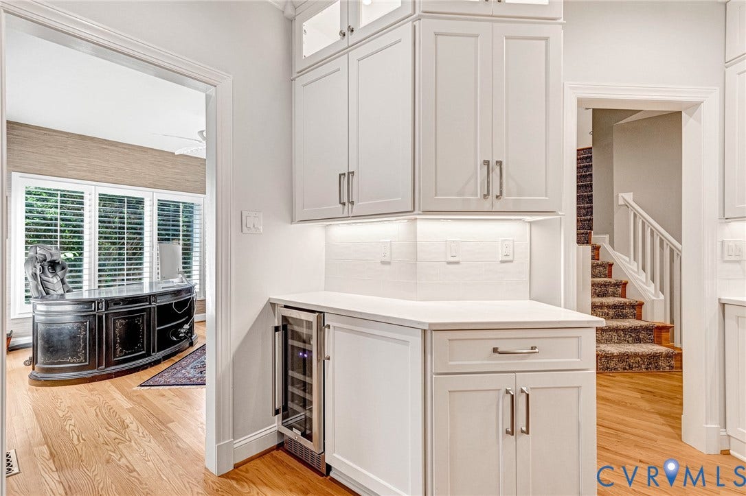 Built-in cabinetry with under-cabinet lighting, integrated beverage cooler, and light-toned countertops