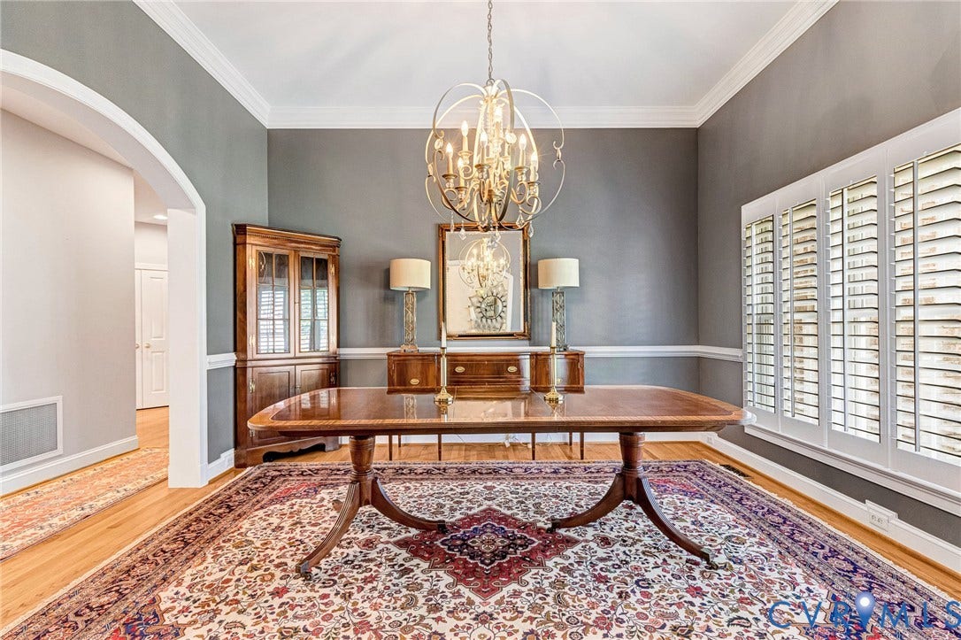 Hardwood flooring, arched entryway, crown molding, chair rail, and plantation shutters