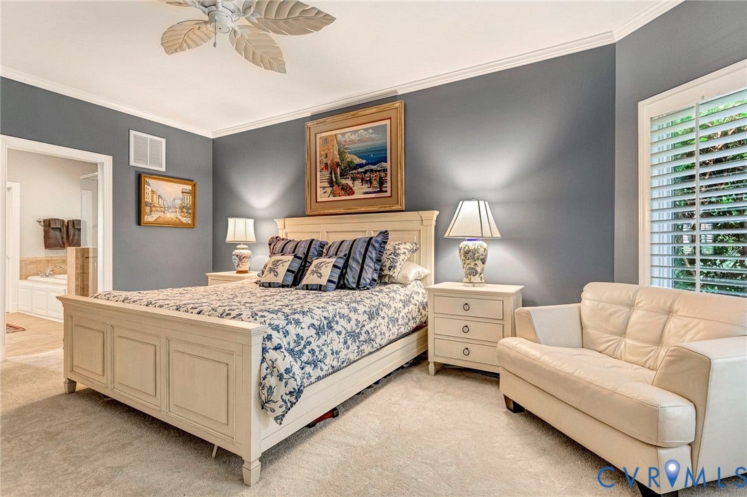 Crown molding, paddle-blade ceiling fan, shuttered window, and broadloom carpeting