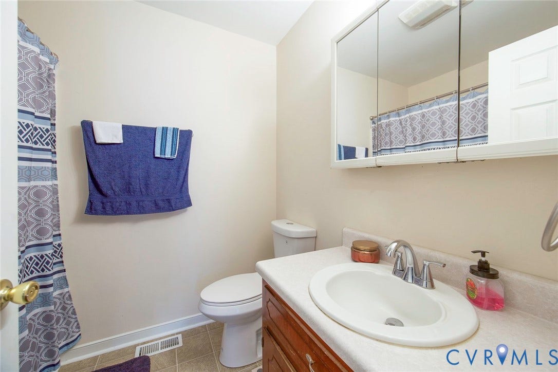 2765 Meadowbrook Street, Petersburg, VA 23803 White oval drop-in sink with chrome faucet, set into a laminate countertop