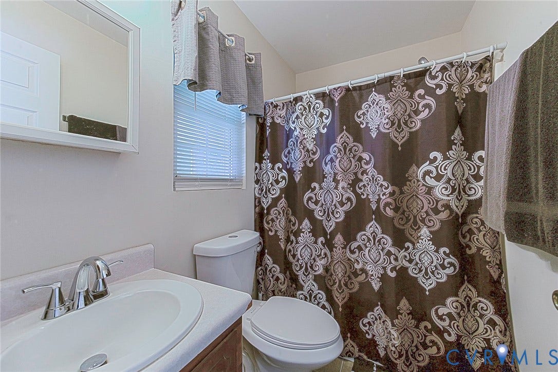 2765 Meadowbrook Street, Petersburg, VA 23803 White vanity with an integrated sink and chrome faucet