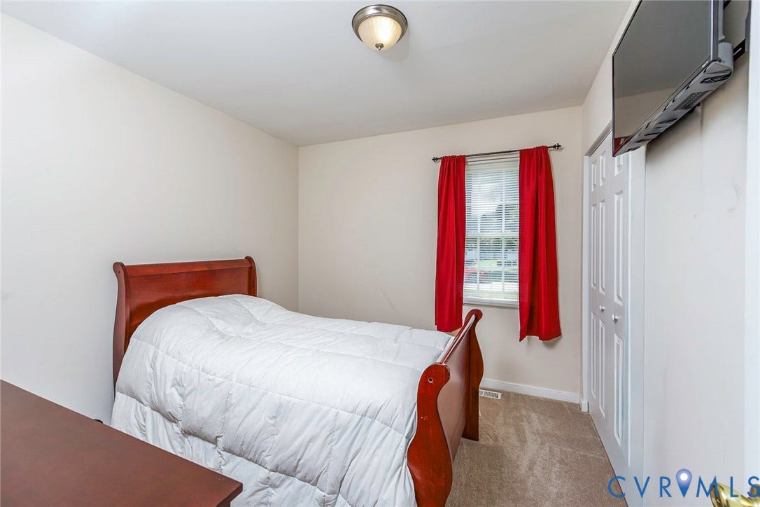 2765 Meadowbrook Street, Petersburg, VA 23803 Neutral wall paint, window with trim, carpeted flooring, and a flush-mount ceiling light fixture