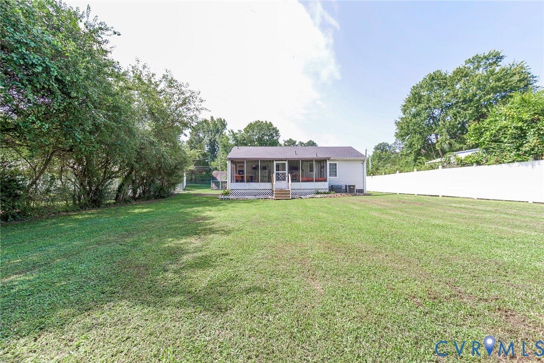 2765 Meadowbrook Street, Petersburg, VA 23803 Expansive rear yard featuring a screened porch, substantial lawn area, mature perimeter landscaping, and a privacy fence