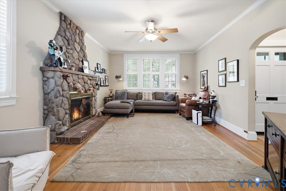 4702 New Kent Avenue, Westover Hills, Richmond, VA 23225 Stone look fireplace with a brick hearth, hardwood flooring, ceiling fan, and multiple windows