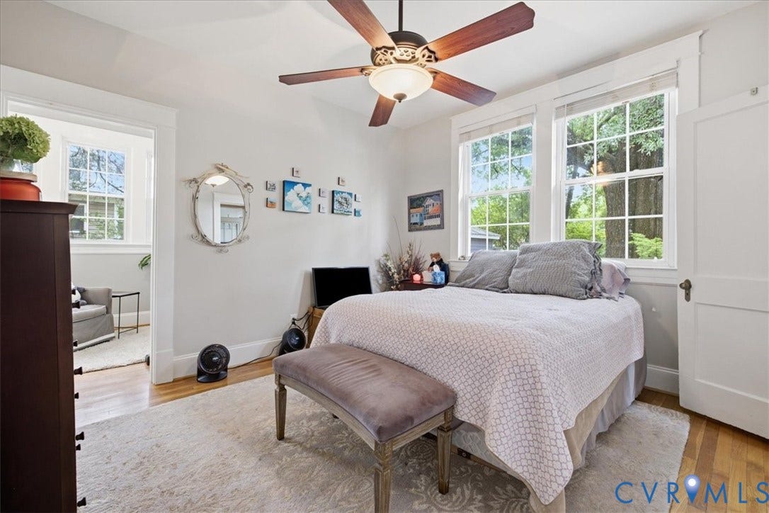 4702 New Kent Avenue, Westover Hills, Richmond, VA 23225 Main floor bedroom with hardwood flooring, painted interior walls, ceiling fan with light fixture, white trim detailing, and transom window