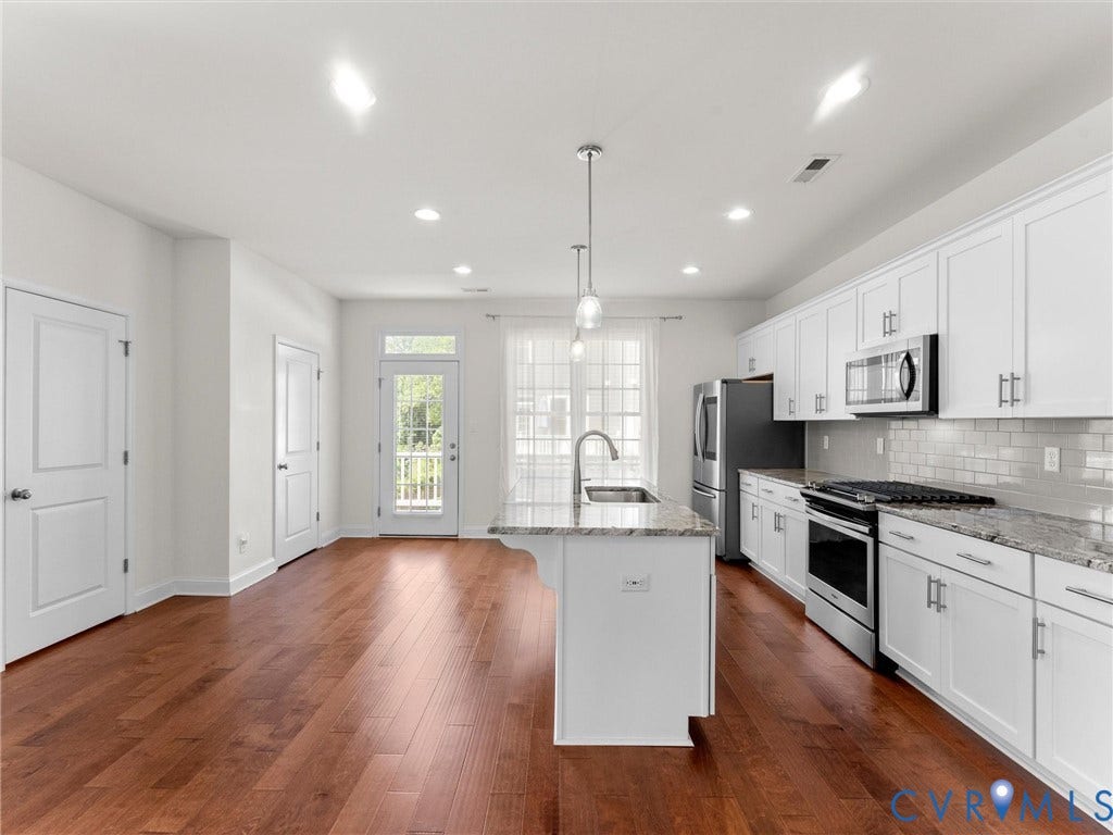 14227 Michaux Village Drive, Winterfield Park, Midlothian, VA 23113 Kitchen featuring wood-finish flooring, white cabinetry, a central island with a sink, stainless steel appliances, and a subway tile backsplash