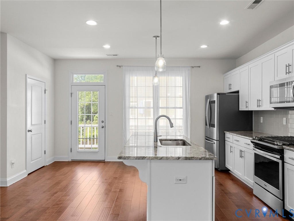 14227 Michaux Village Drive, Winterfield Park, Midlothian, VA 23113 Kitchen featuring a center island with sink, stainless steel appliances, white cabinetry, and wood-finish flooring