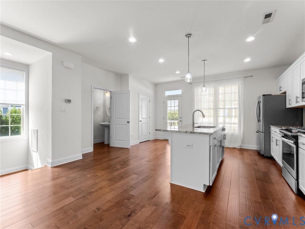14227 Michaux Village Drive, Winterfield Park, Midlothian, VA 23113 Open-concept living space with wood-finish flooring, white cabinetry, a kitchen island with stone countertops, and recessed lighting