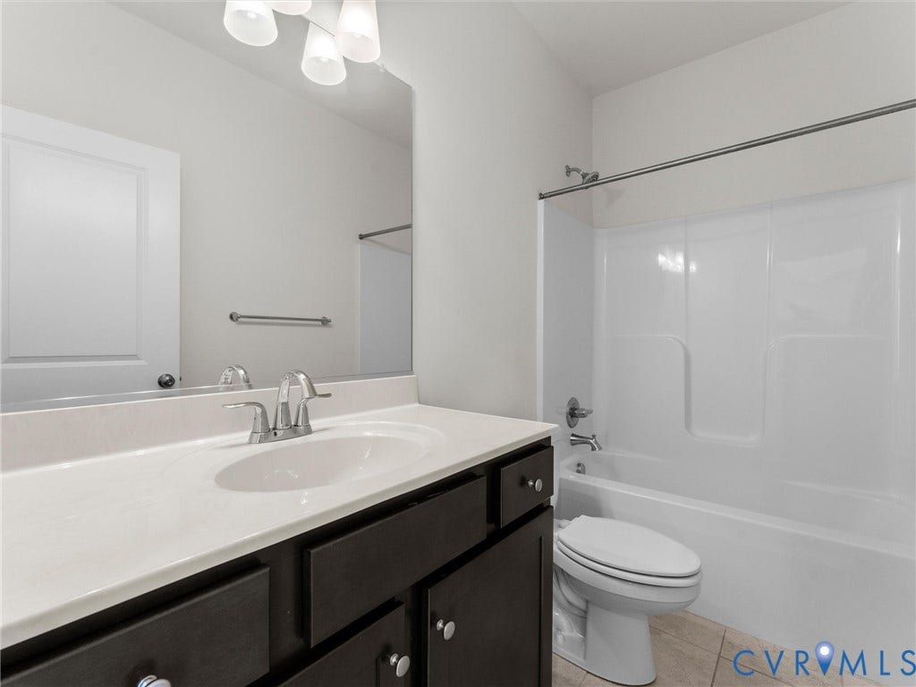 14227 Michaux Village Drive, Winterfield Park, Midlothian, VA 23113 Vanity with dark wood-finish cabinetry, integrated sink, wall-mounted mirror, and overhead light fixture