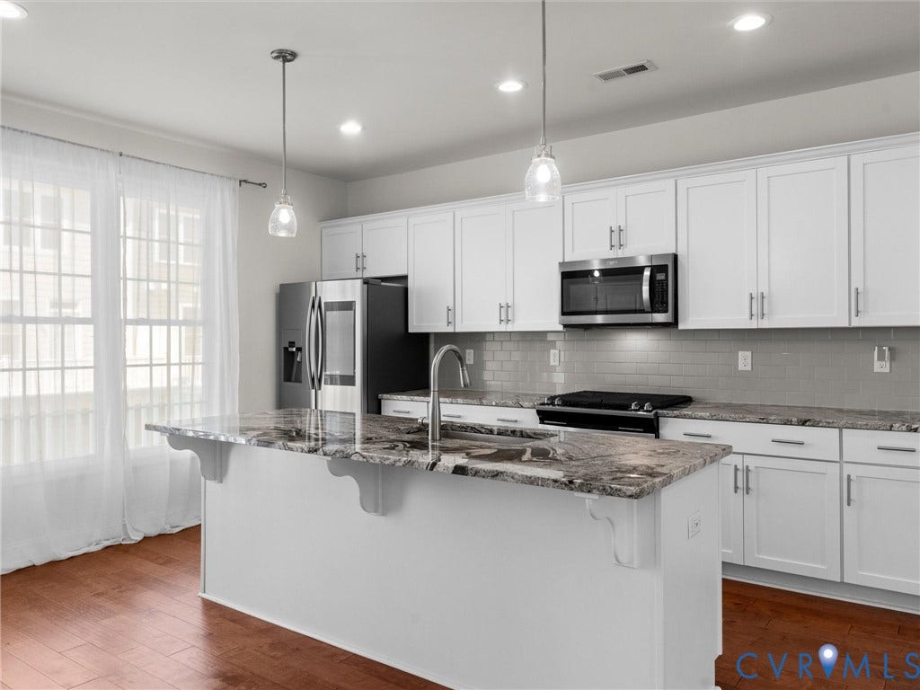 14227 Michaux Village Drive, Winterfield Park, Midlothian, VA 23113 Kitchen featuring a central island with a stone countertop, white cabinetry, stainless steel appliances, a gray subway tile backsplash, and wood-finish flooring