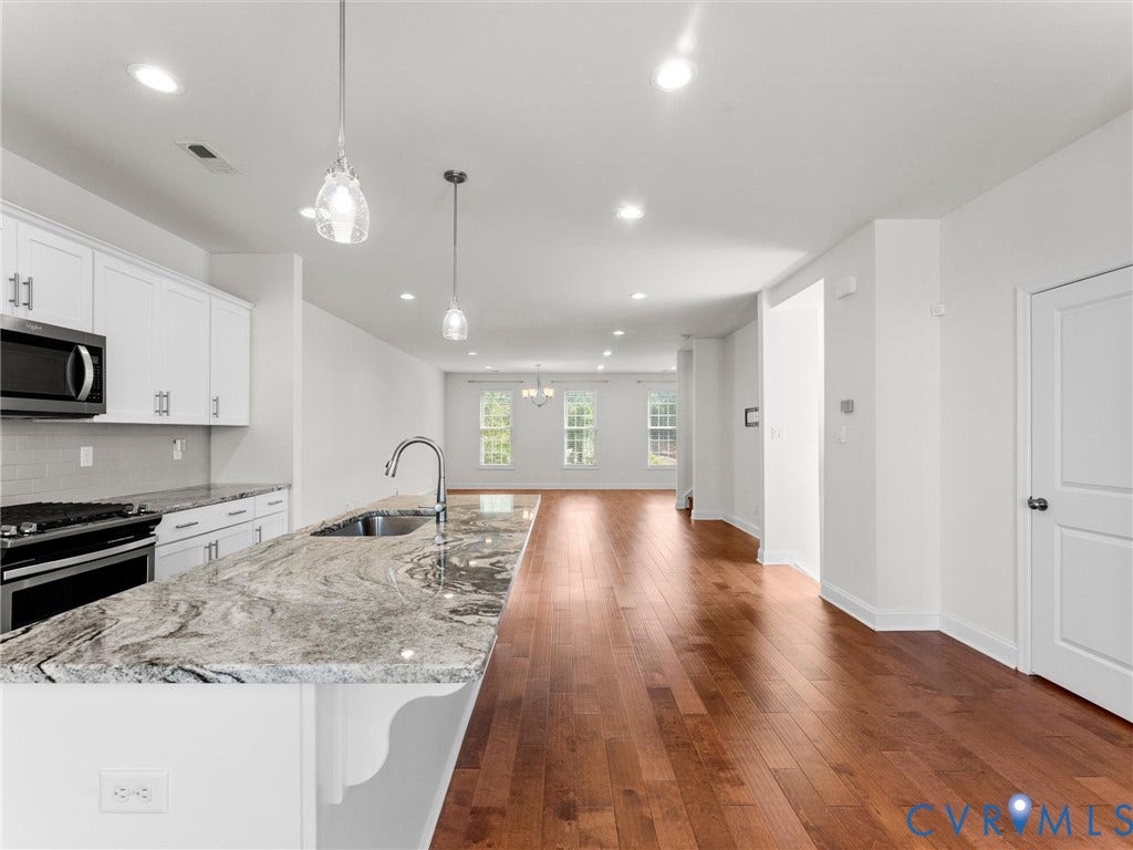 14227 Michaux Village Drive, Winterfield Park, Midlothian, VA 23113 Kitchen featuring an expansive island with a stone countertop, white shaker cabinetry, stainless steel appliances, and wood-finish flooring throughout