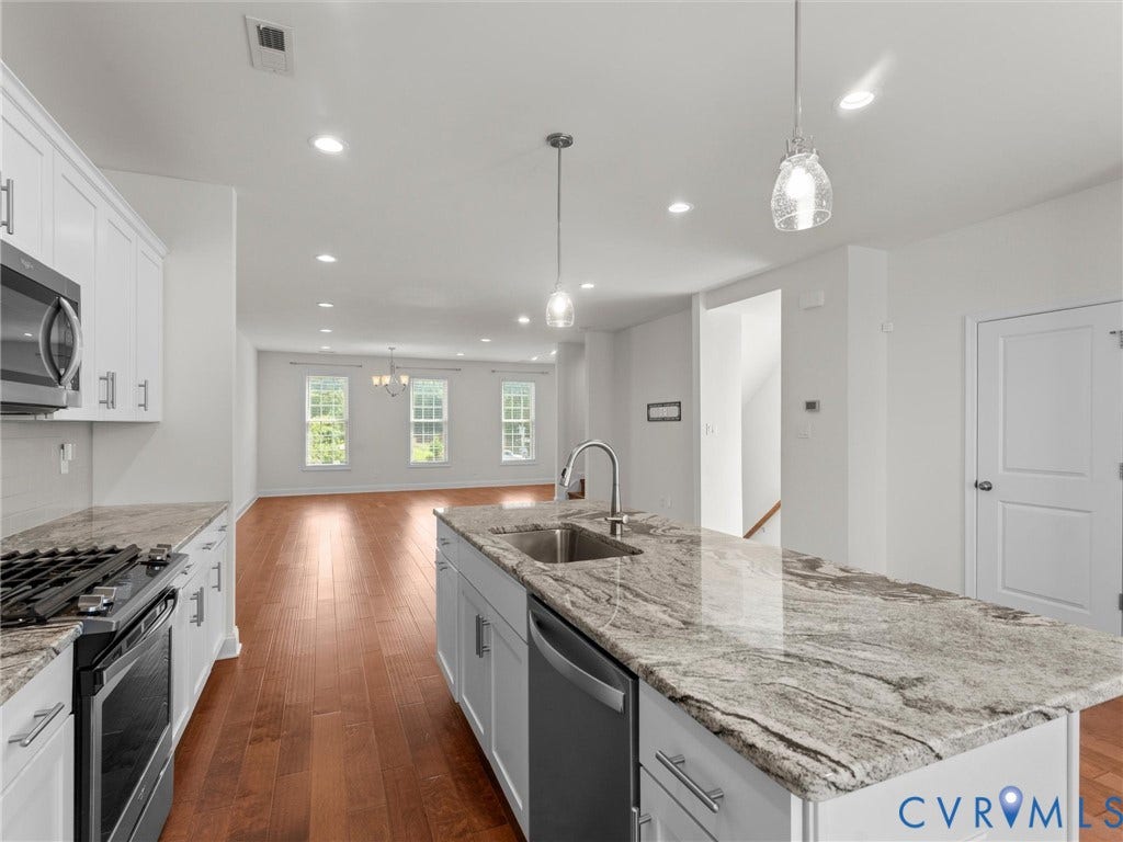 14227 Michaux Village Drive, Winterfield Park, Midlothian, VA 23113 Bright kitchen featuring white cabinetry, a large kitchen island with a built-in sink, stainless steel appliances, and recessed lighting