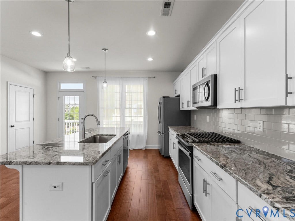 14227 Michaux Village Drive, Winterfield Park, Midlothian, VA 23113 Kitchen featuring stainless steel appliances, white cabinetry, a subway tile backsplash, and a central island with a sink