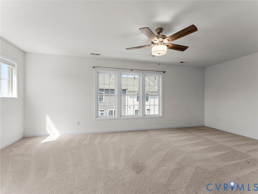 14227 Michaux Village Drive, Winterfield Park, Midlothian, VA 23113 Spacious room featuring multiple windows, neutral carpeting, and a ceiling fan with integrated lighting