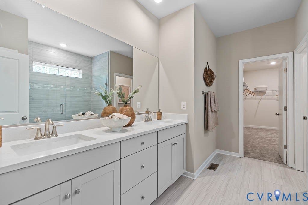 16074 Greenhart Drive, Chesterfield, VA 23832 Double vanity with integrated sinks, brushed nickel fixtures, a full-width mirror, and a glass-enclosed shower with tile surround