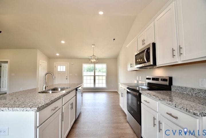 410 Kents Mill Rd, Louisa, VA 23093 Kitchen featuring white cabinetry, stainless steel appliances, speckled countertops, and wood-finish flooring