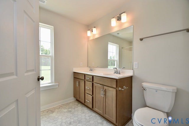 410 Kents Mill Rd, Louisa, VA 23093 Dual vanity with wood-finish cabinetry, white countertop, and integrated sinks