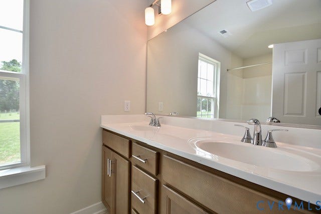 410 Kents Mill Rd, Louisa, VA 23093 Dual vanity with integrated sinks, chrome faucets, and wood-finish cabinetry