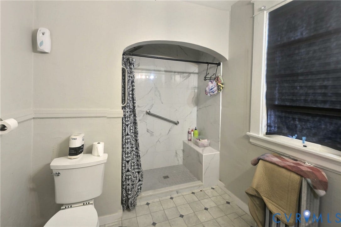 2811 Woodcliff Avenue, Richmond, VA 23222 Shower with marble-finish tile surround, built-in bench, and grab bar