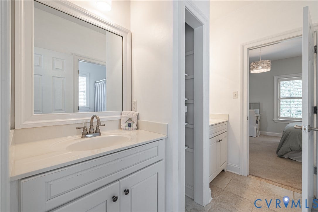 12917 Holmbank Lane, Henrico, VA 23233 Shared bath-vanity with an integrated sink and brushed nickel faucet, a built-in storage niche, and tile flooring