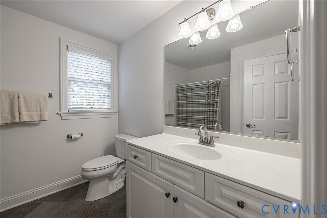 12917 Holmbank Lane, Henrico, VA 23233 Vanity with a single basin sink, large wall mirror, and overhead vanity lighting