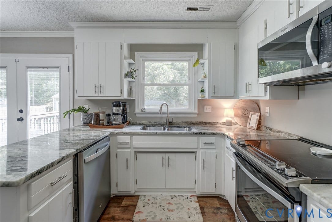 4647 Brookridge Road, Chesterfield, VA 23832 White cabinetry, stainless steel appliances, stone countertops, wood-finish flooring, and a double-door exterior access