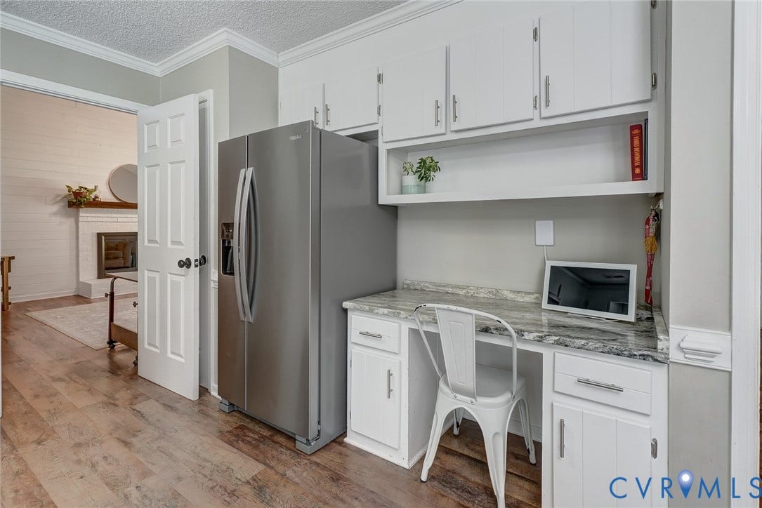 4647 Brookridge Road, Chesterfield, VA 23832 Wood-finish flooring, built-in desk with stone-finish countertop, white cabinetry with silver-finish hardware, stainless steel refrigerator, and crown molding