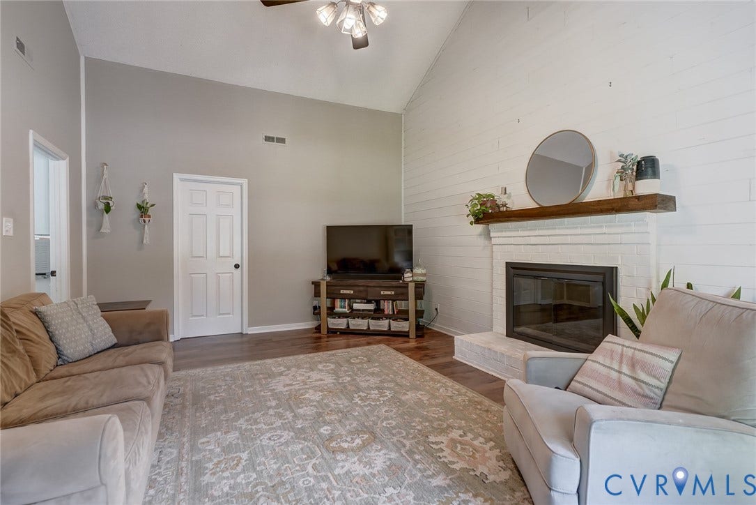 4647 Brookridge Road, Chesterfield, VA 23832 Vaulted ceiling, wood-finish flooring, white shiplap accent wall, fireplace with brick surround, and a wood mantel