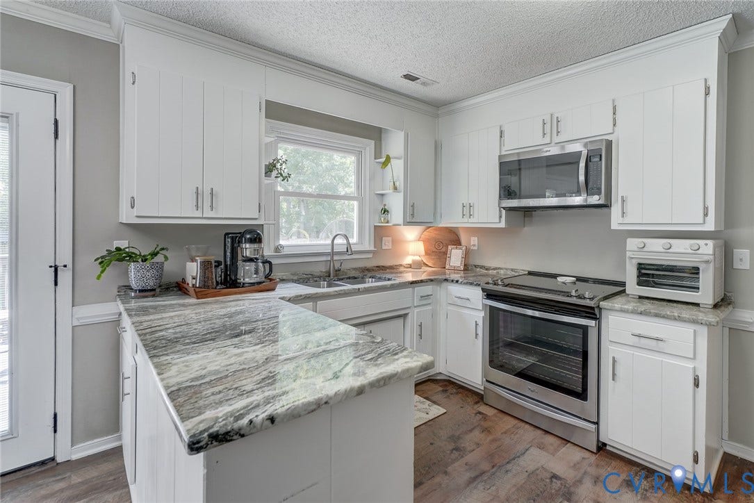 4647 Brookridge Road, Chesterfield, VA 23832 U-shaped kitchen with white cabinetry, stainless steel appliances, variegated stone countertops, and wood-finish flooring