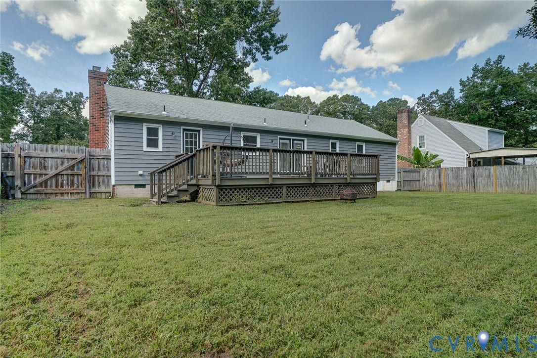 4647 Brookridge Road, Chesterfield, VA 23832 Expansive backyard featuring a large wooden deck with railings, grey horizontal siding, and two brick chimneys