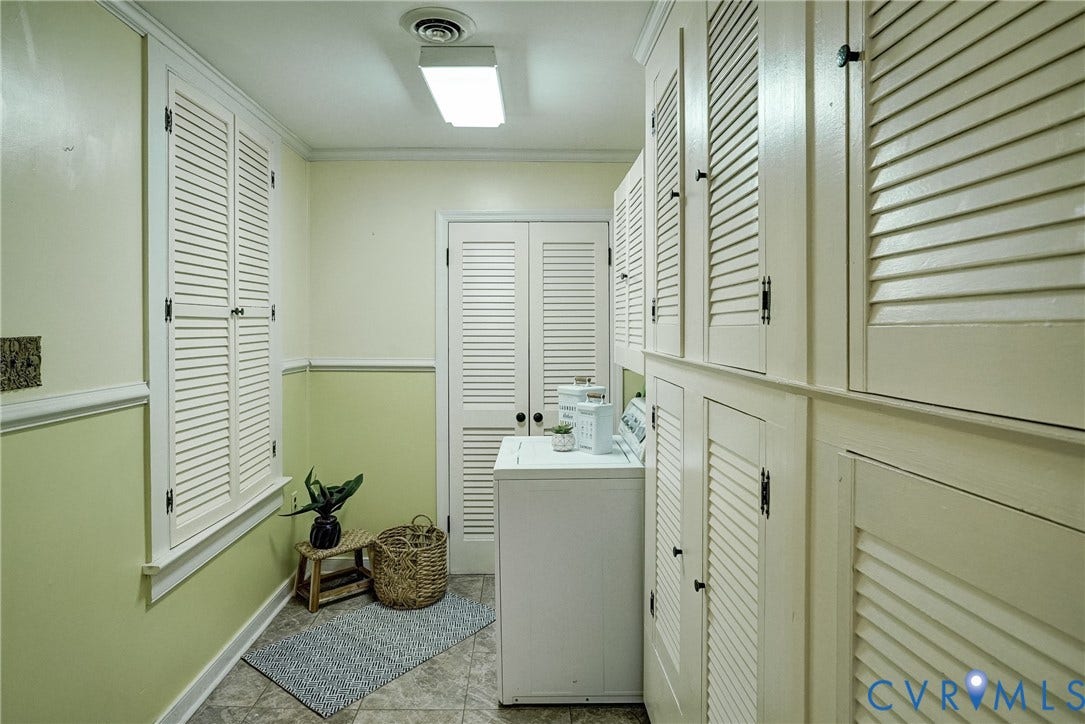 Tile flooring, upper and lower louvered cabinetry, and a fluorescent ceiling light fixture