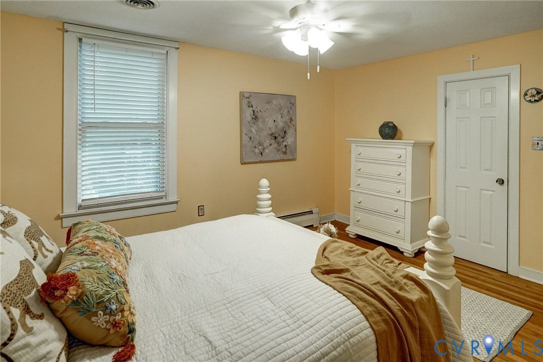 Hardwood flooring, ceiling fan with light fixture, single window with blinds,