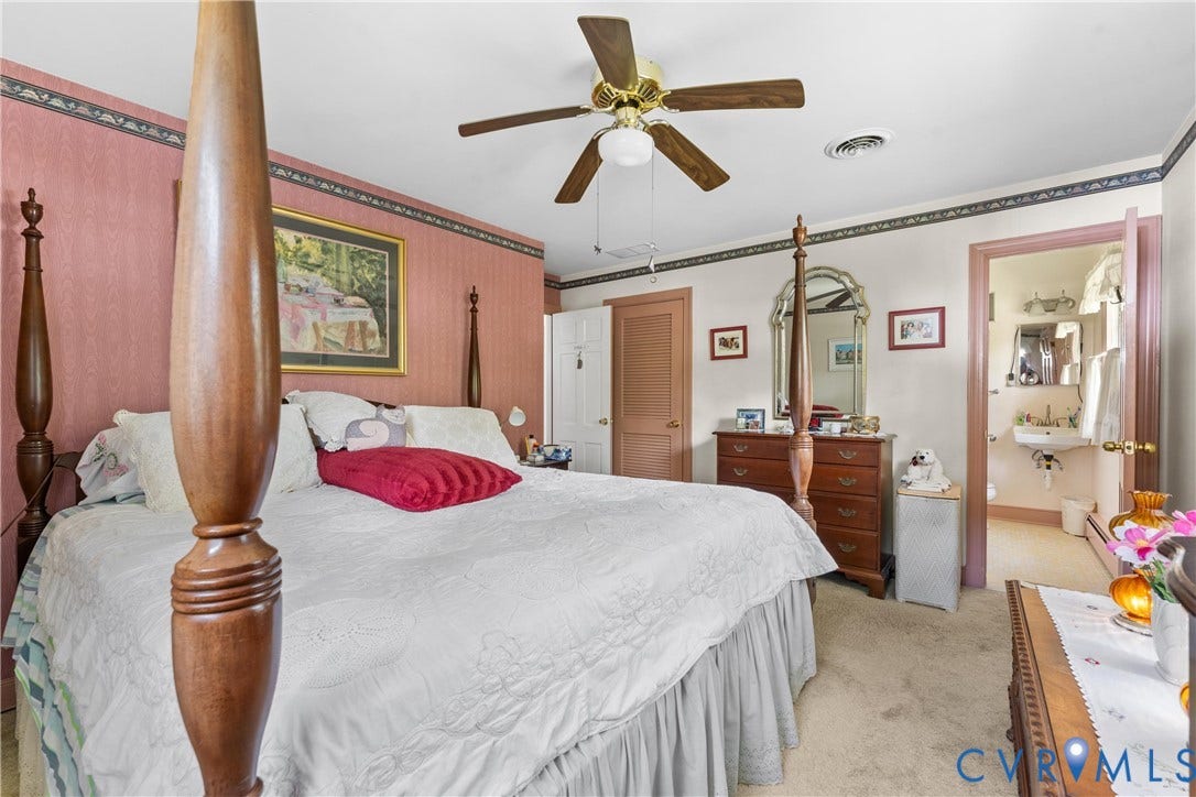 10205 Gwynnbrook Road, Richmond, VA 23235 Carpeted flooring, ceiling fan with light fixture, and direct access to an attached bathroom featuring a pedestal sink and wall-mounted mirror